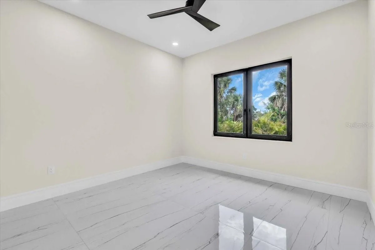 Unfurnished bedroom with a single window and ceiling fan.