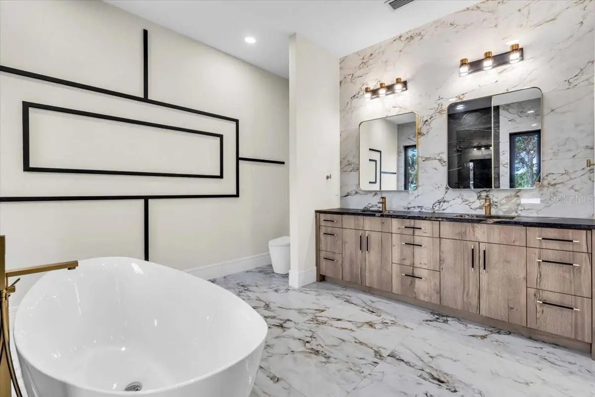 Primary bath with bold geometric wall art and a freestanding soaking tub.