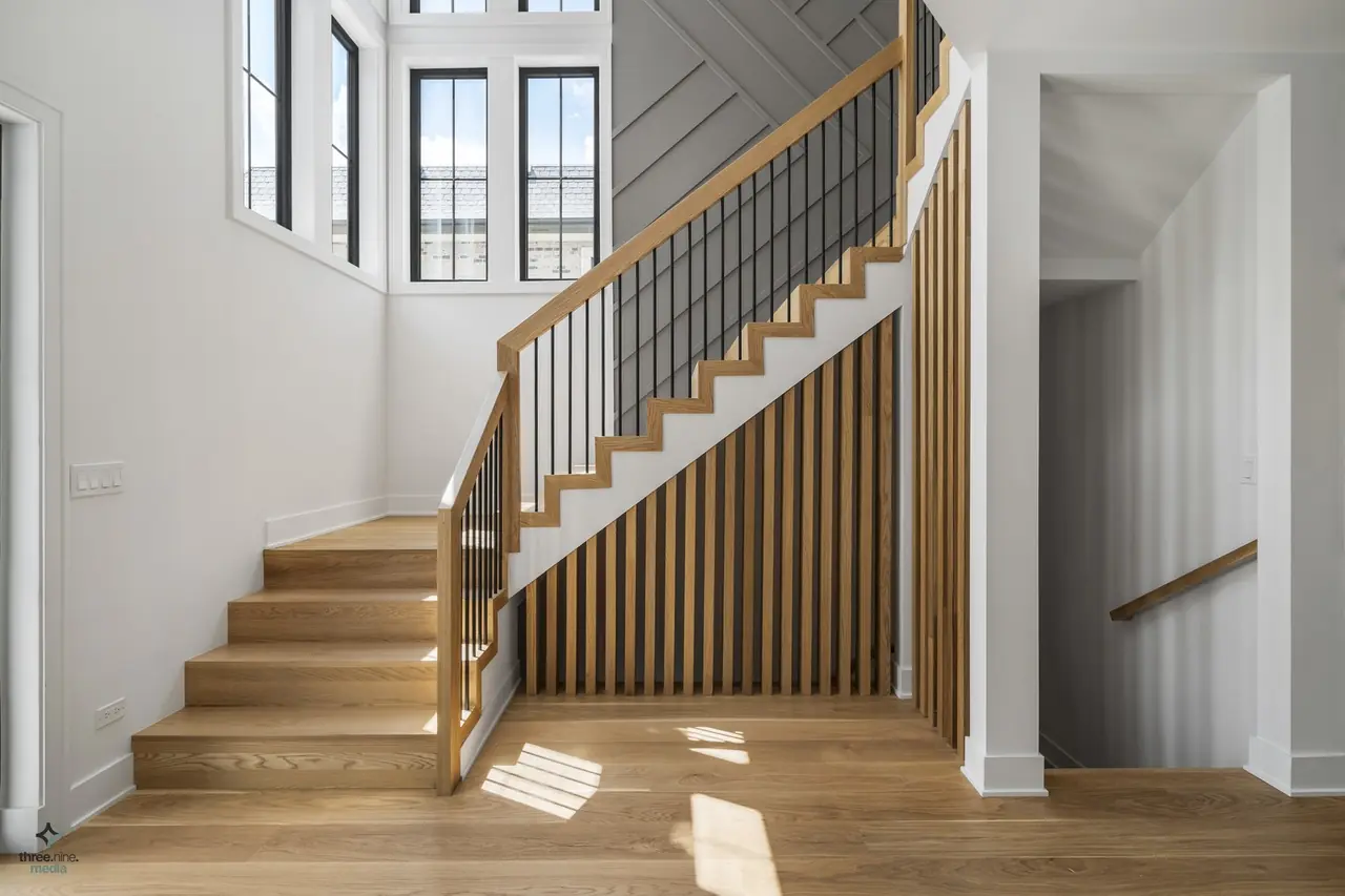 Custom staircase with white oak treads and a black metal-and-wood railing