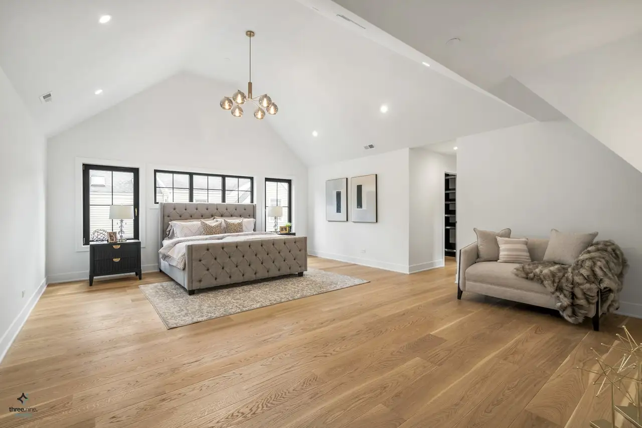 Vaulted primary suite with a tufted upholstered bed and chaise lounge, Northbrook, IL