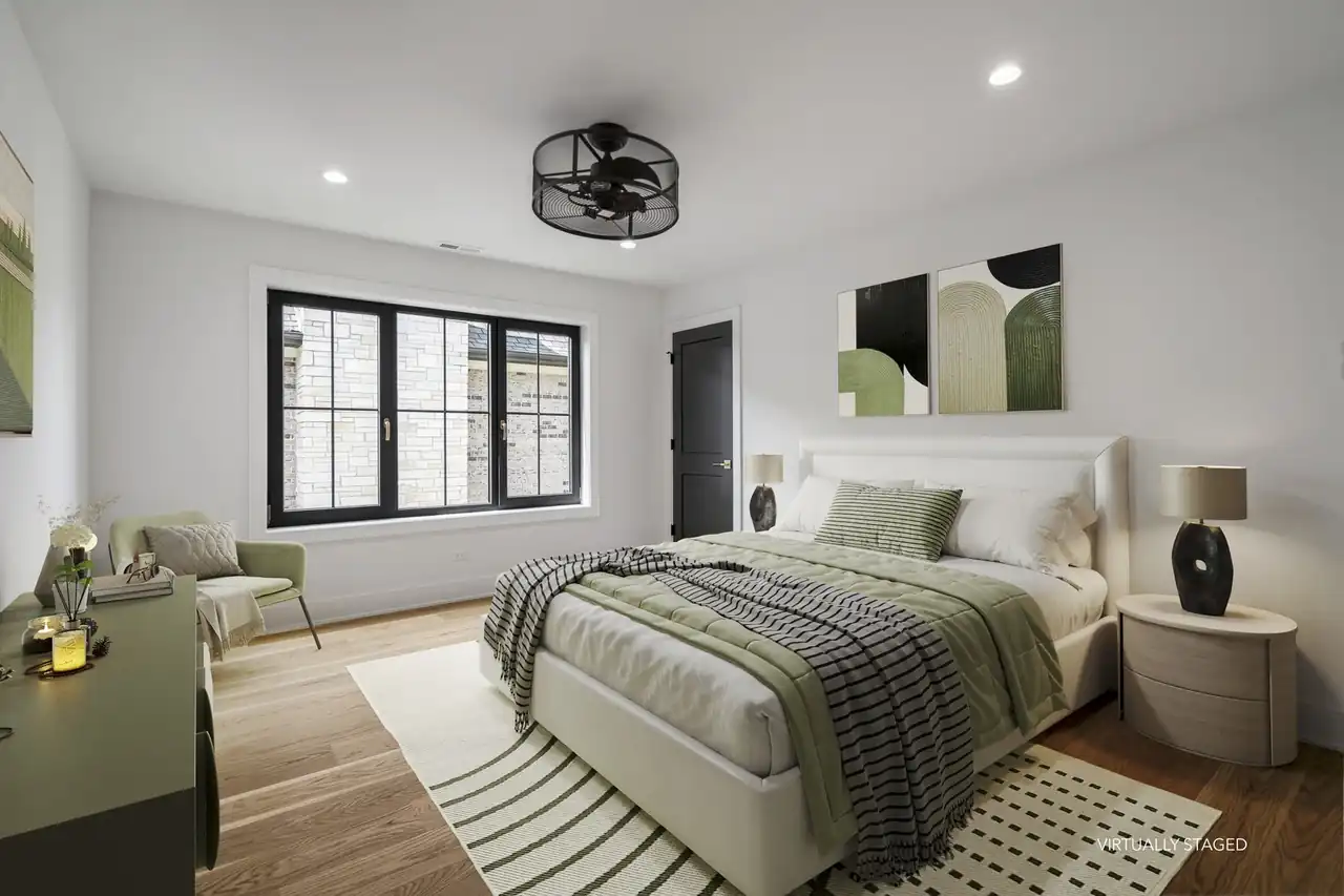 Virtually staged bedroom with sage accents and a black paneled door