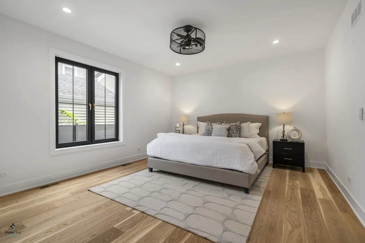 Guest bedroom with an upholstered taupe bed and dark wood nightstands