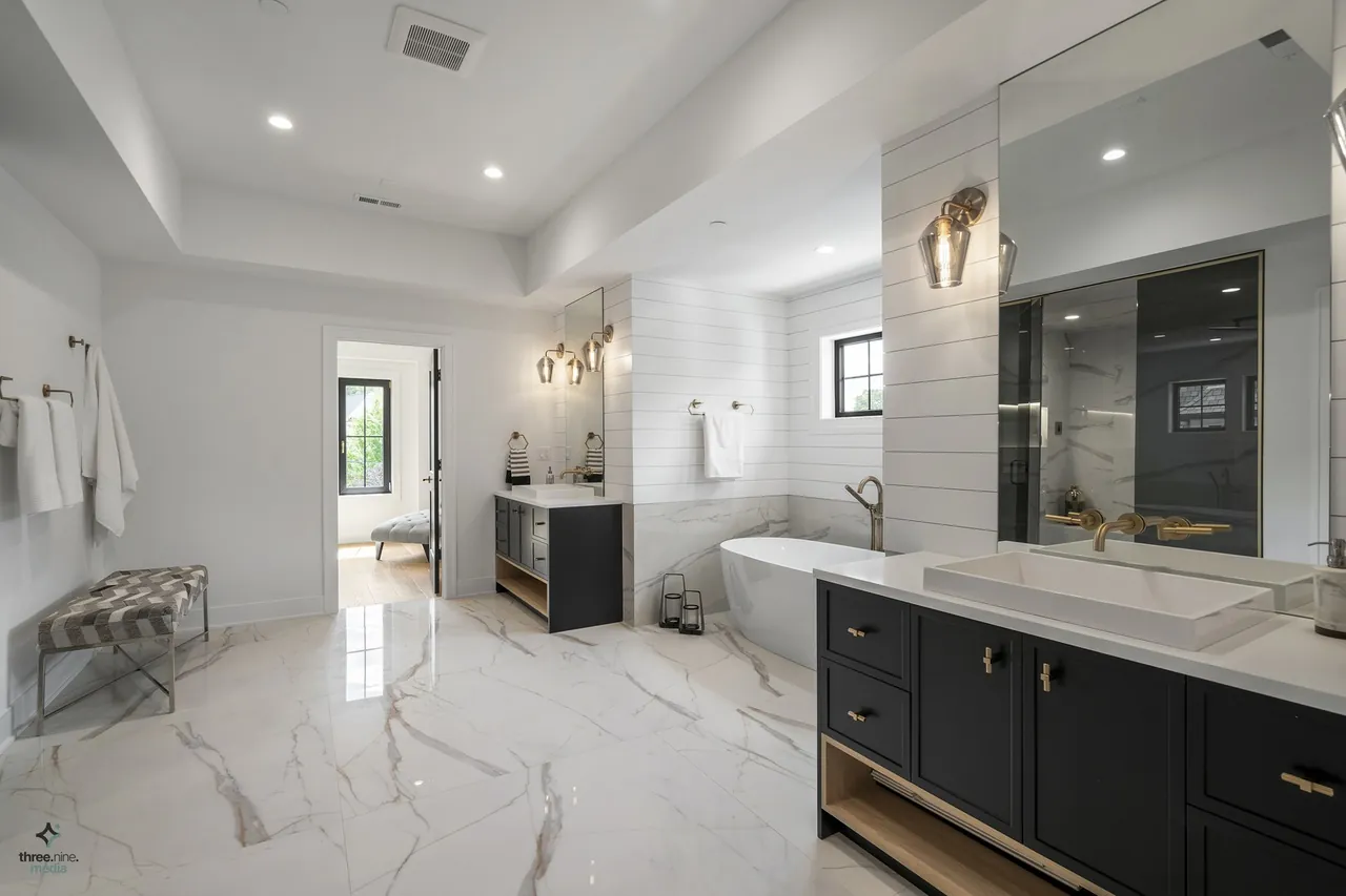 Primary bathroom with a freestanding soaking tub set beneath a shiplap alcove