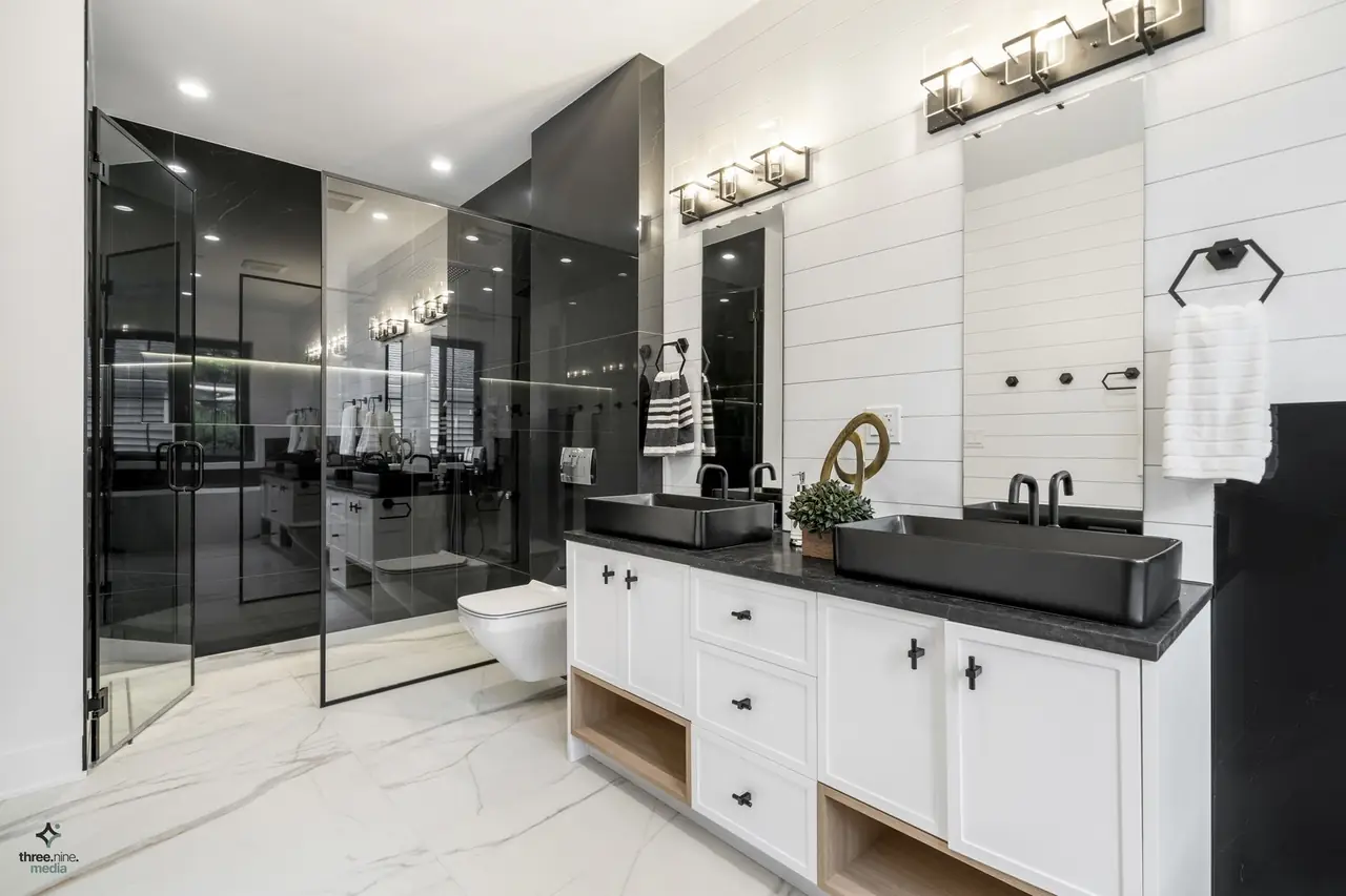 Bathroom with matte black vessel sinks and a black stone countertop