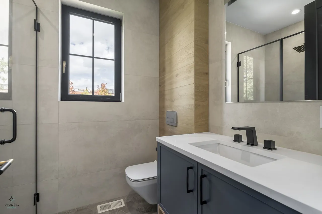 Bathroom with a walk-in glass shower and navy vanity cabinet