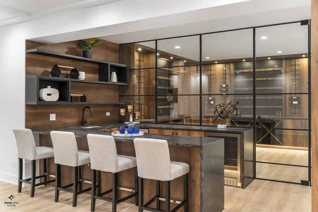 Wet bar with dark wood cabinetry, open shelving, and a glass-enclosed wine room