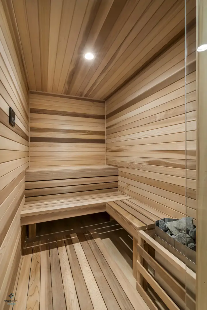 Cedar sauna with tiered wood benches and a glass door