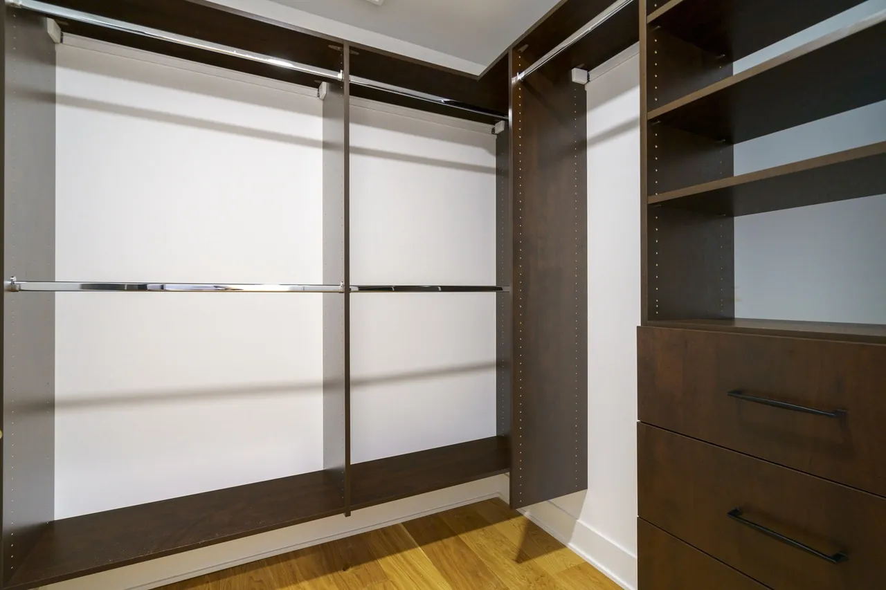 Walk-in closet with built-in shelving and chrome hanging rods