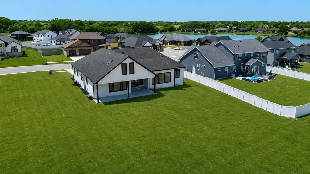 Aerial view of the completed home and surrounding Saint John, IN neighborhood, with a lake in the distance.