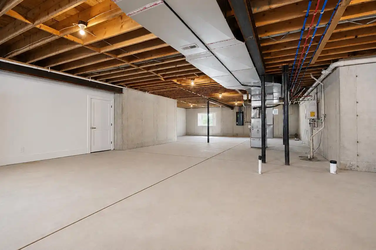 Unfinished basement mechanical area showing the furnace, PEX plumbing lines, and electrical panel.