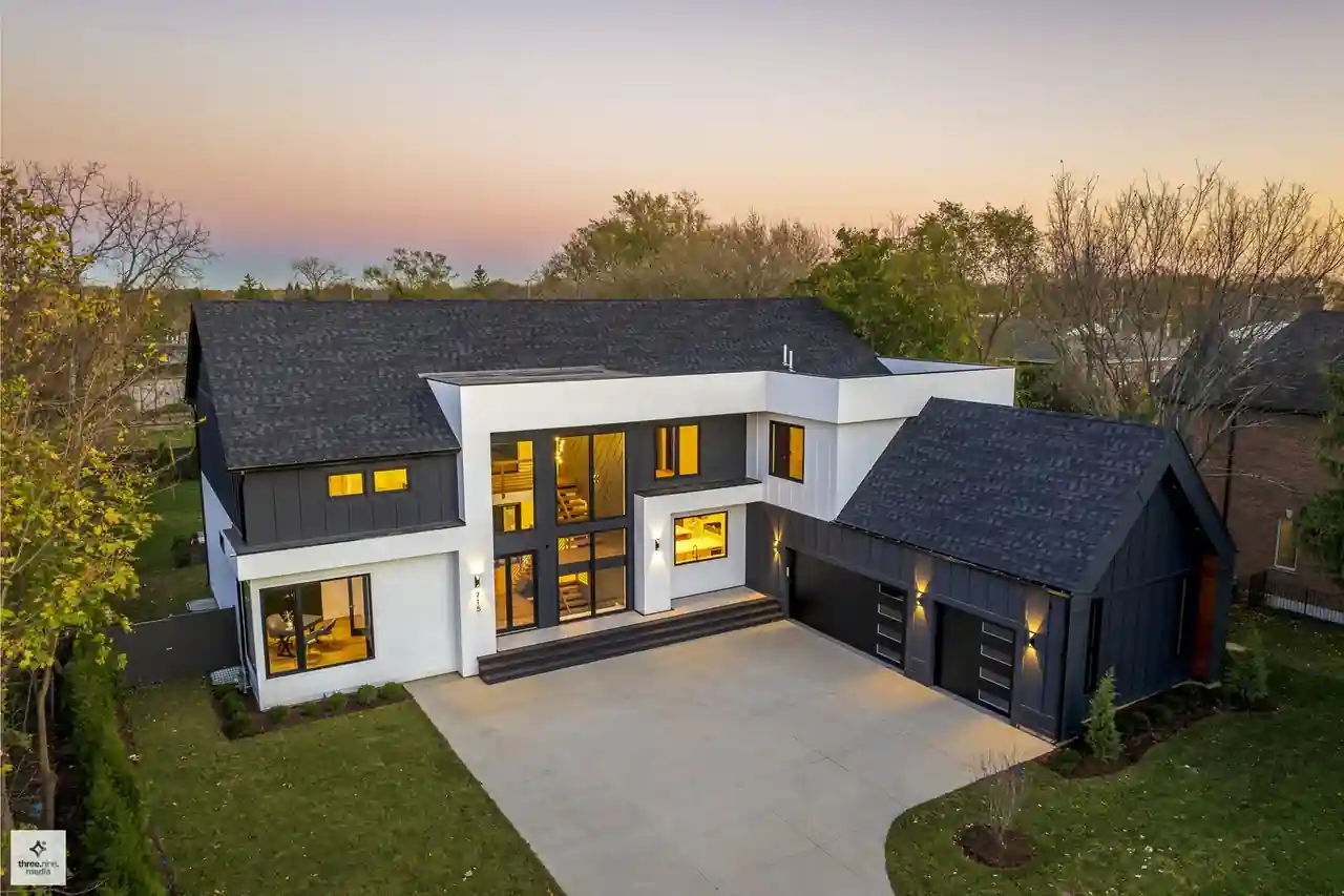 Aerial dusk view of the Chapel New Construction home's black-and-white exterior with three-car garage in Northbrook, IL