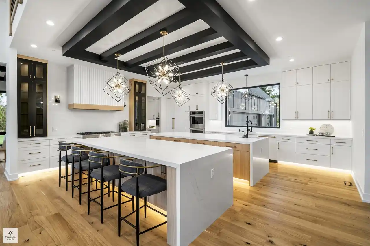 Kitchen view toward the oven wall, natural wood cabinetry, and black-striped ceiling beams