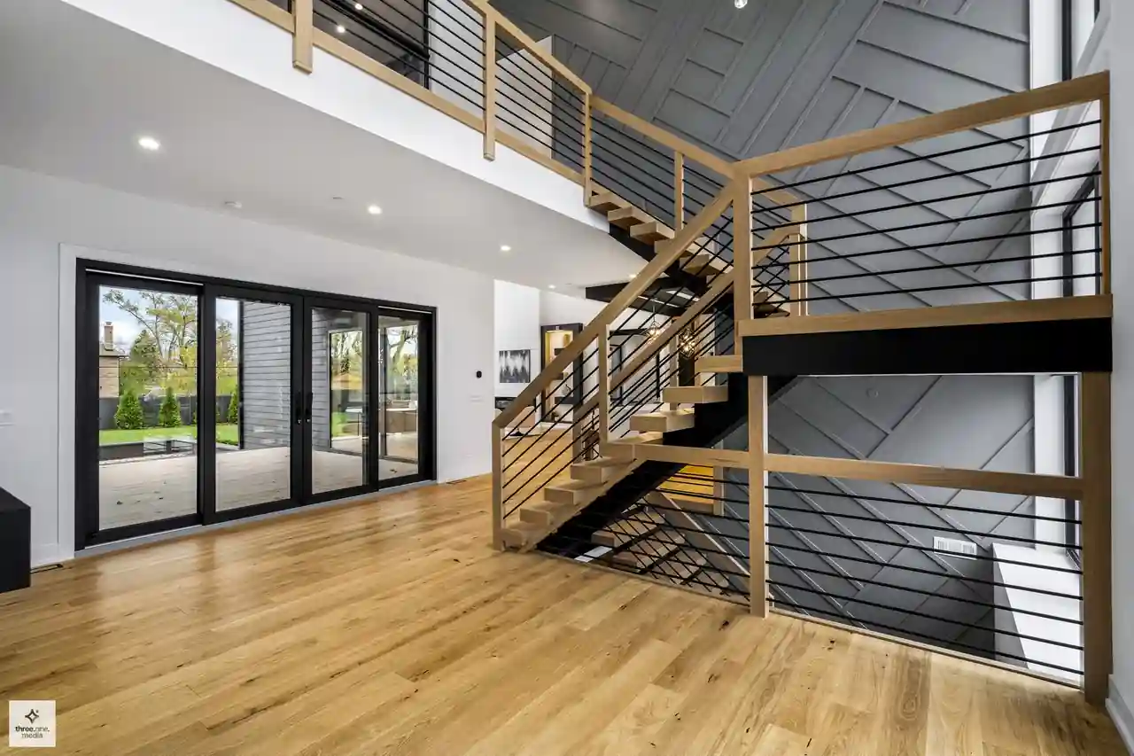Staircase landing beside black sliding glass doors leading to the rear deck