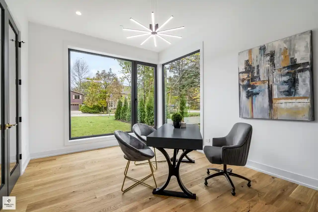 Corner office nook with wraparound windows and abstract wall art