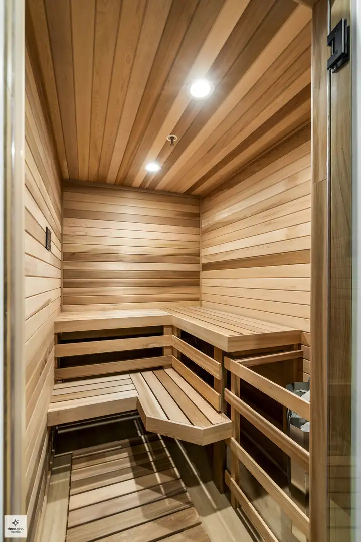 Cedar sauna with tiered wood benches, part of the home's spa-style lower level
