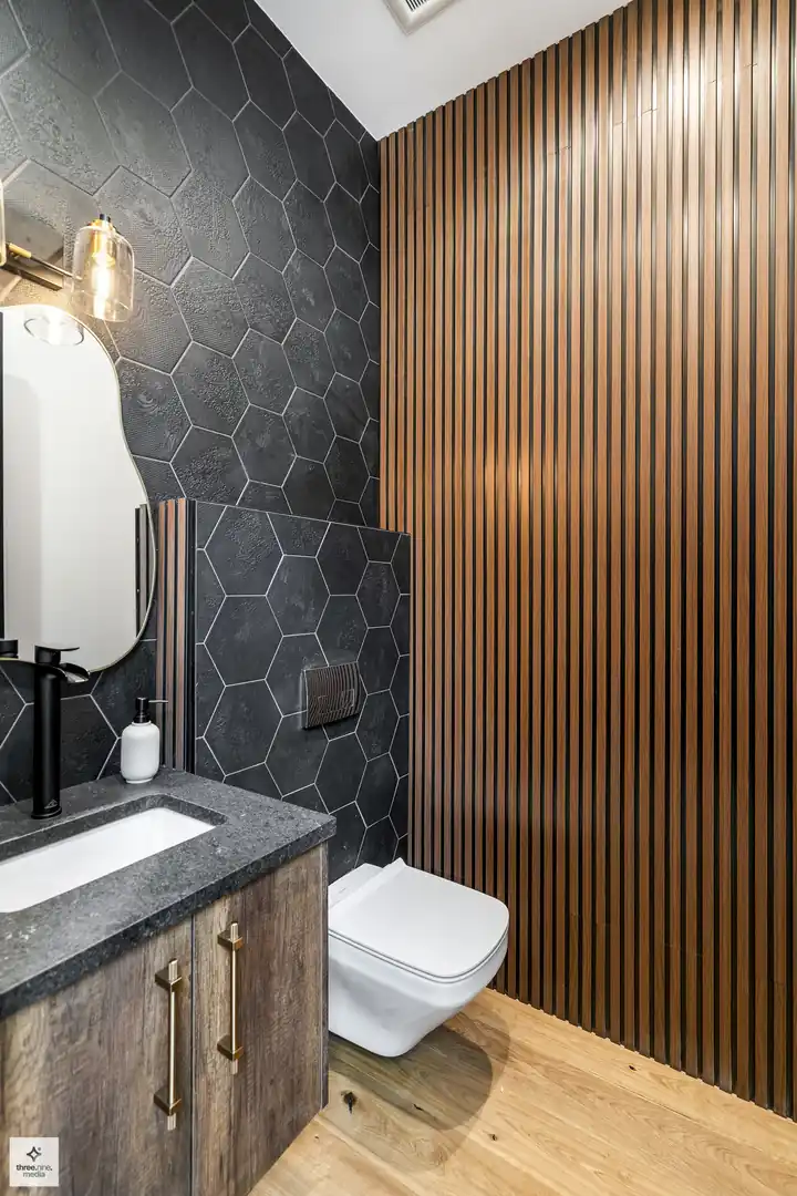 Powder room with black hexagon tile and a vertical wood slat accent wall