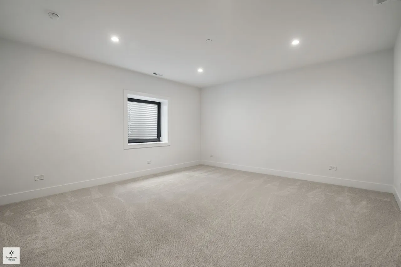 Unfurnished carpeted bedroom with a single window and recessed lighting