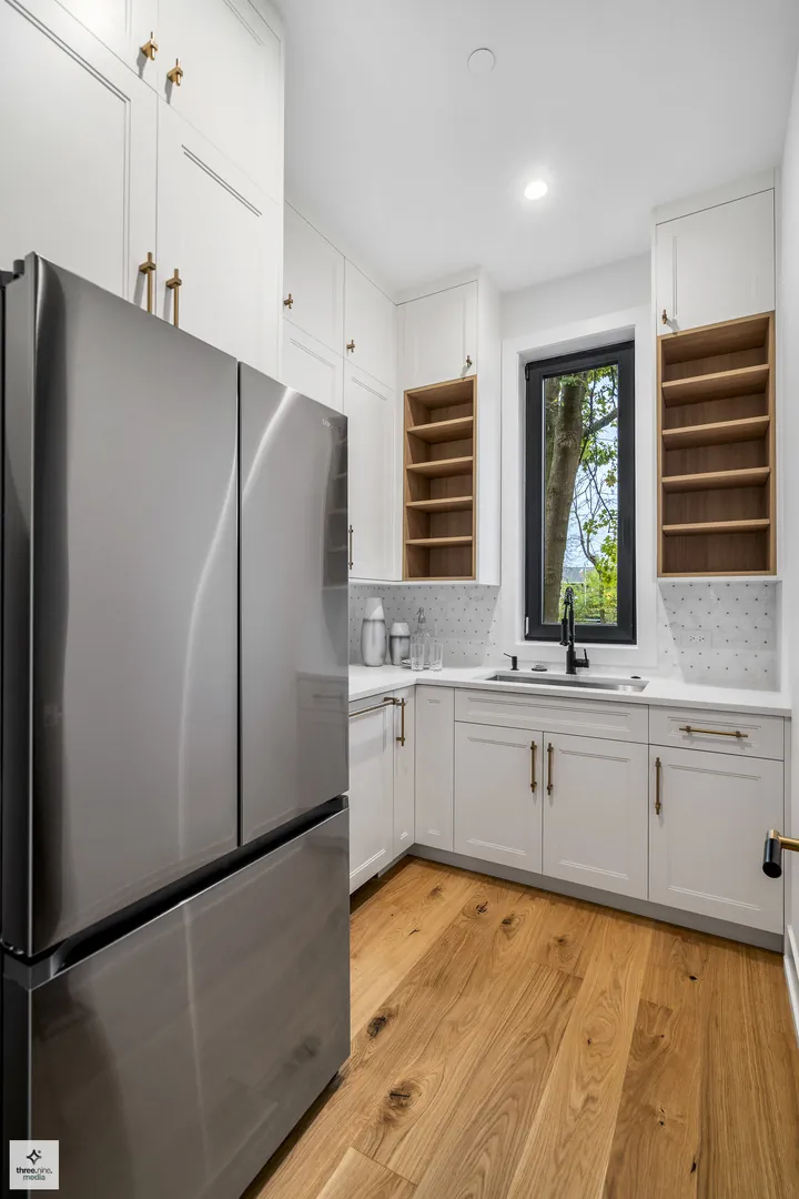Butler's pantry with a stainless refrigerator and open wood shelving