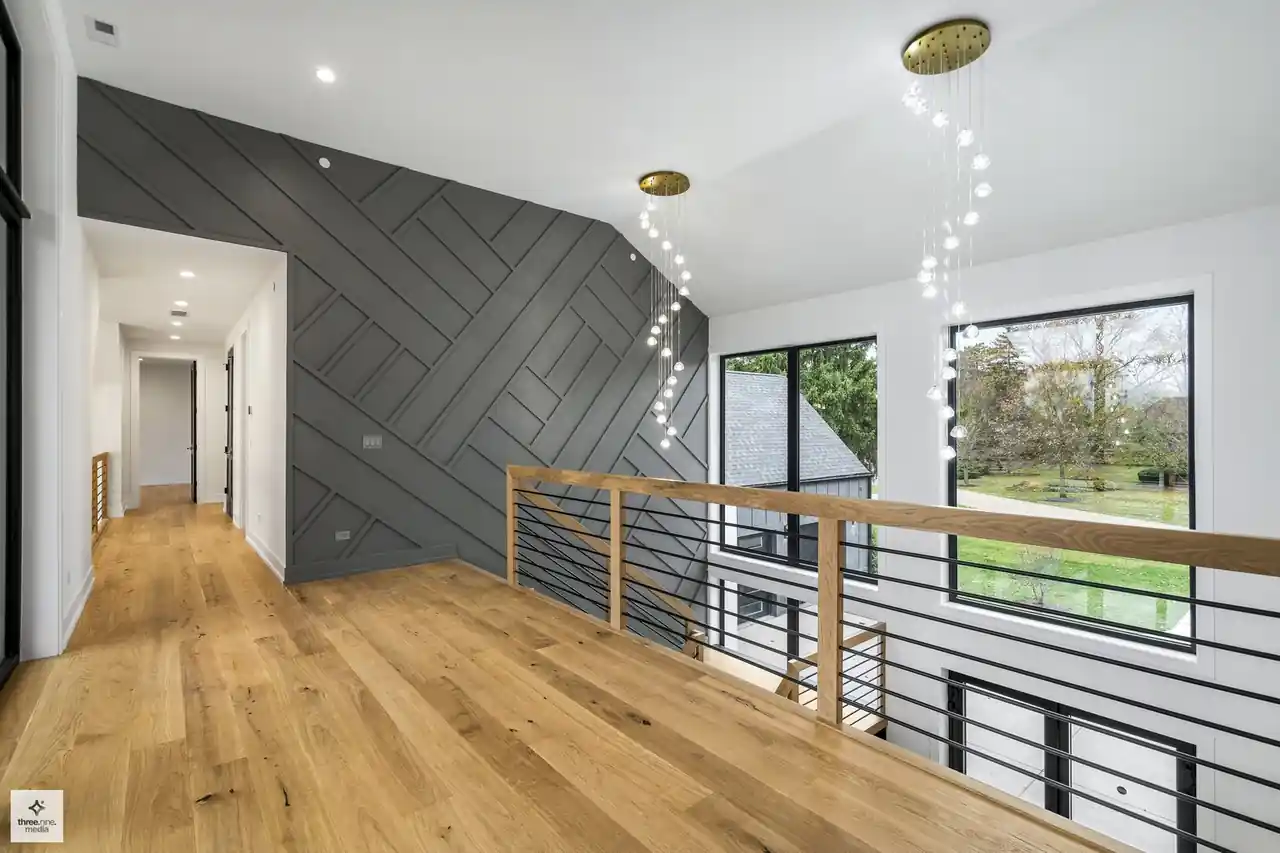 Upper-level landing with a herringbone accent wall and cable stair railing