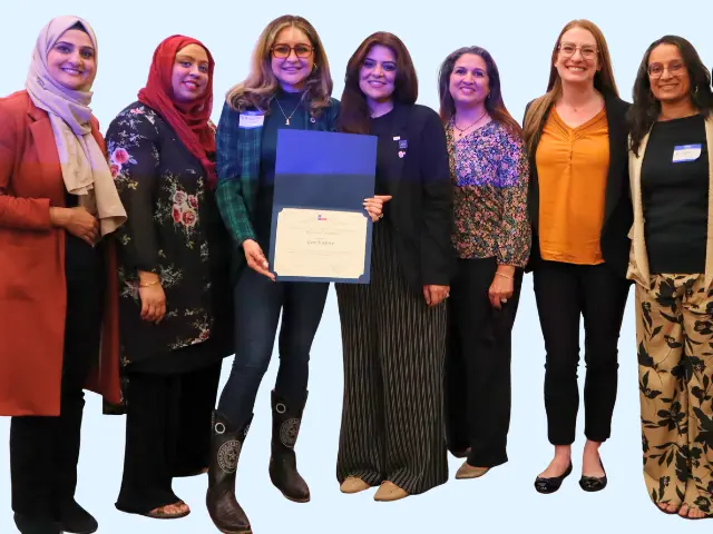 six staff members posing with a framed award