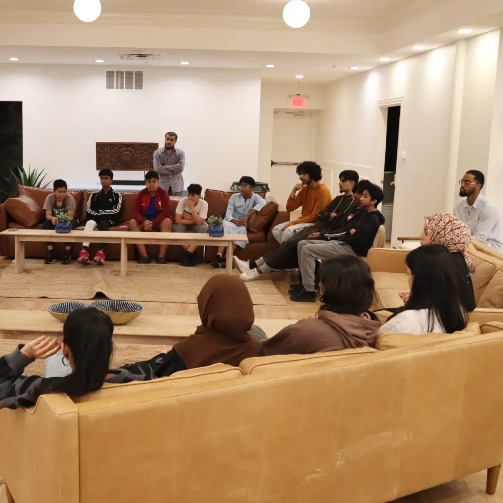 youth and adults gathered in community room watching a presentation