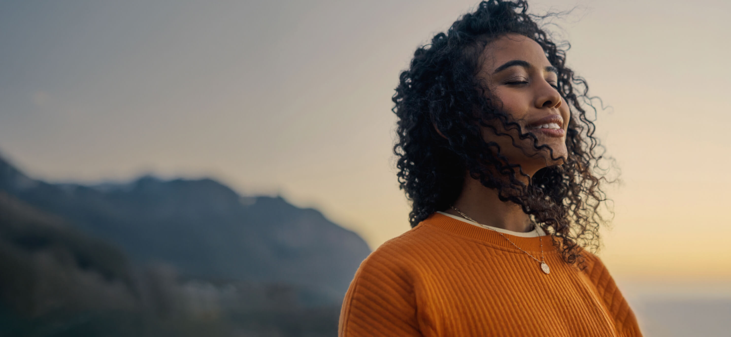 Person with eyes closed at sunrise