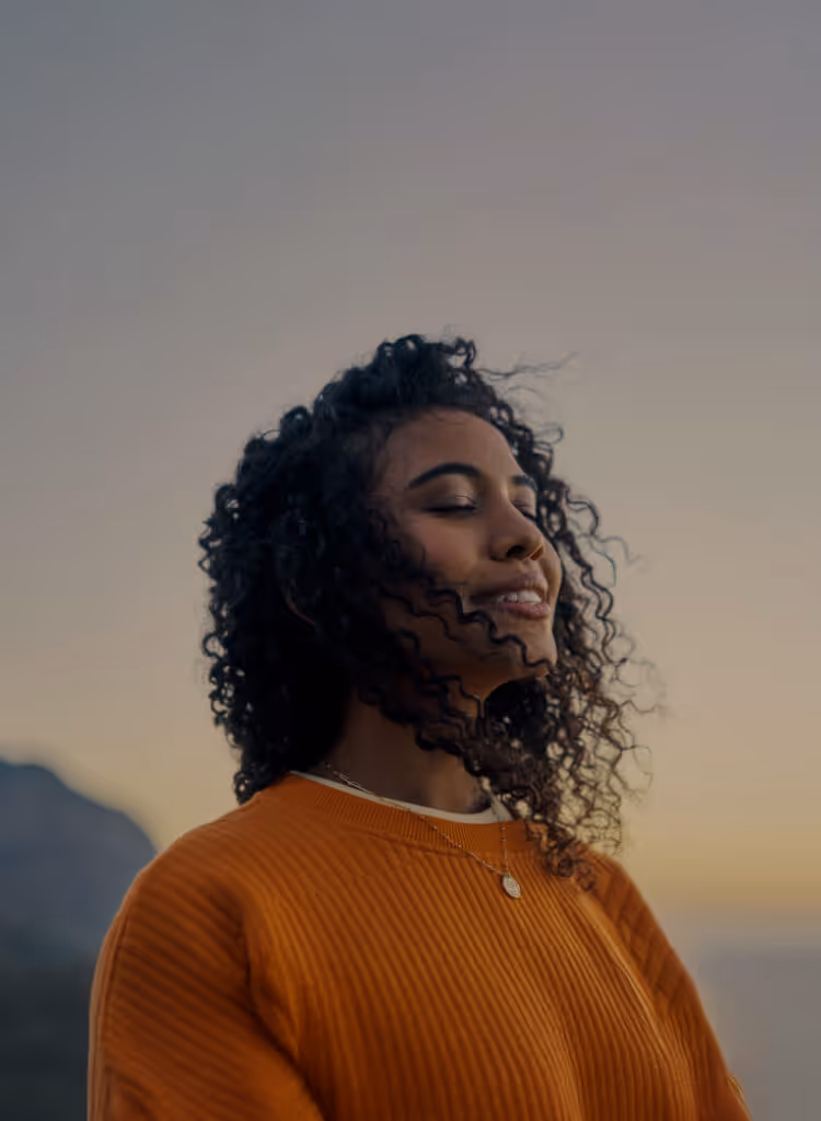 Person with eyes closed at sunrise