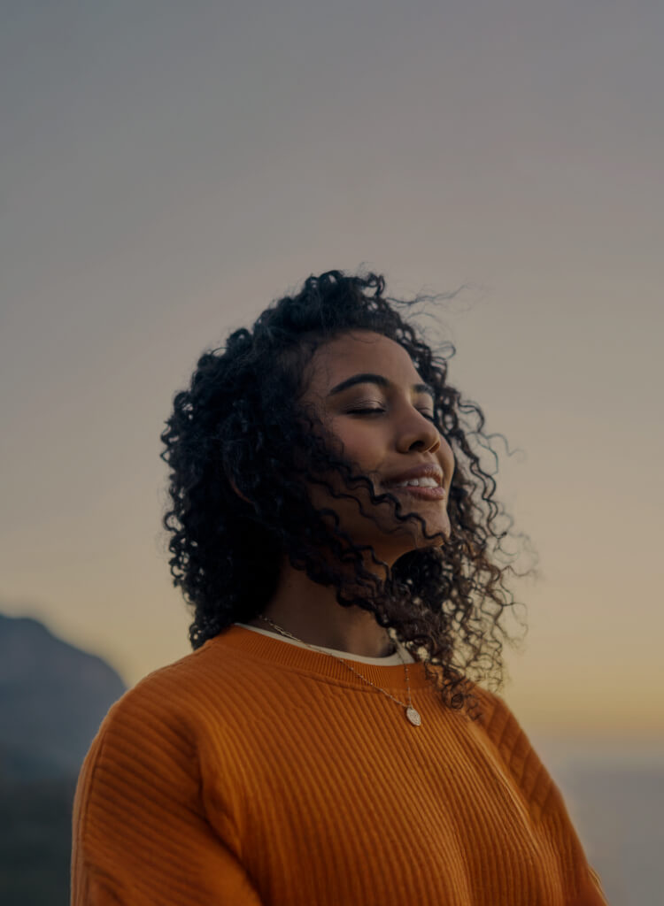 Person with eyes closed at sunrise