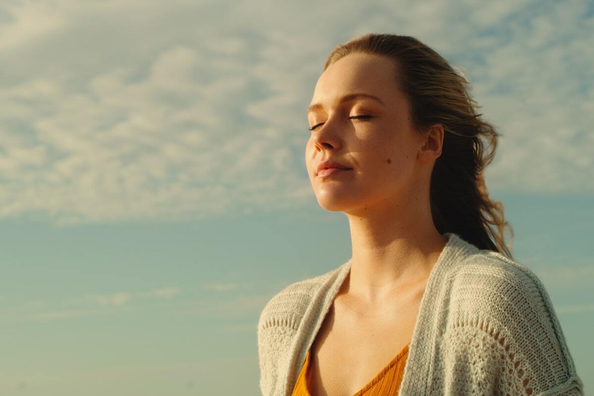 Person standing in the sun, eyes closed