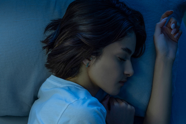 Person sleeping with their head on a pillow