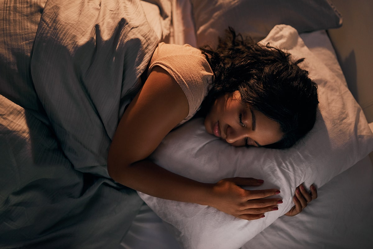 Person sleeping with their head on a pillow