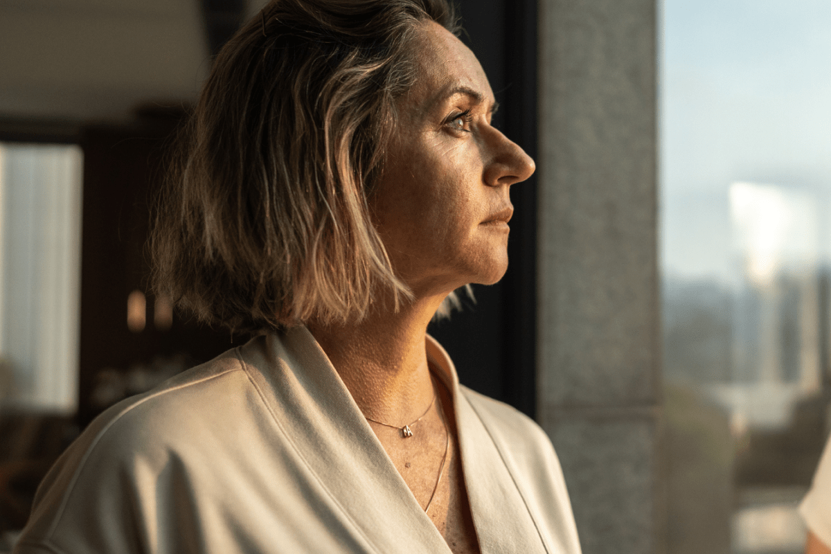 Female Office worker staring out the window of her office building. 