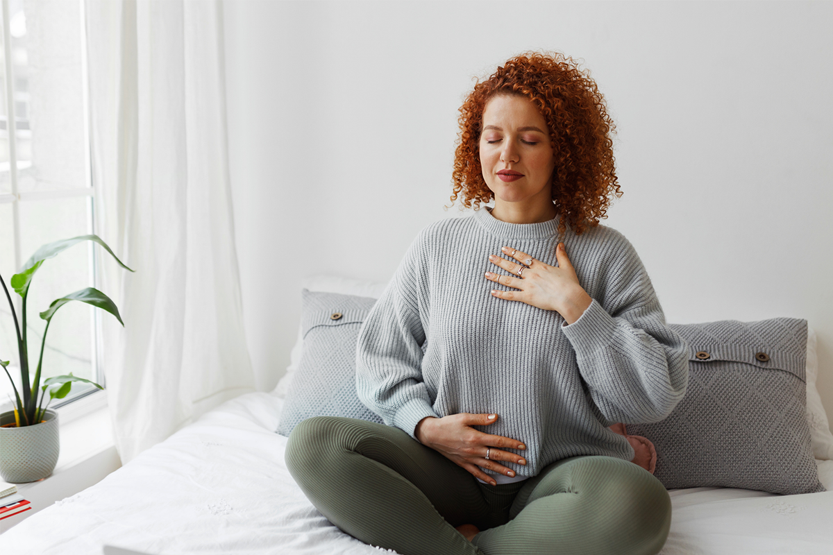 Young woman focusing on her breathe in a upright mediation pose.