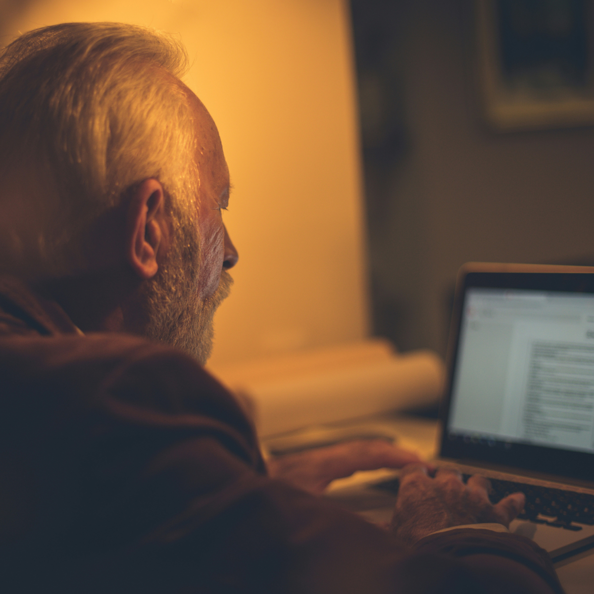 Elderly man using a laptop for a telehealth consult