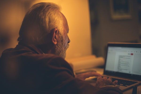 Elderly man using a laptop for a telehealth consult