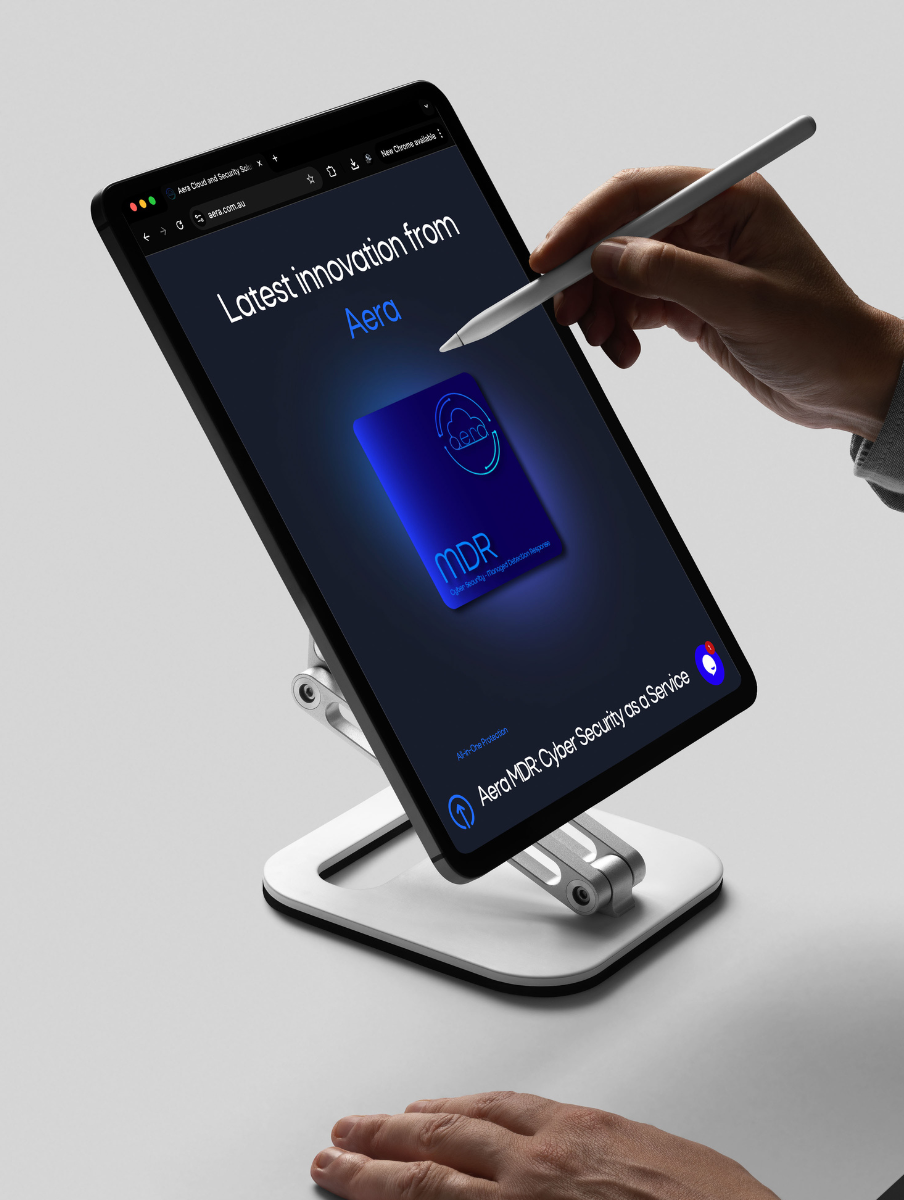 Tablet on a stand with a hand using a stylus to interact with a screen displaying 'Latest innovation from Aera' and 'Aera MDR Cyber Security as a Service'.
