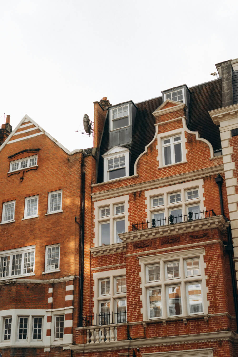 Red-brick buildings with white-trimmed windows and architectural details under a clear sky.