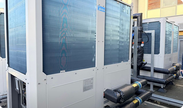 Large outdoor industrial air conditioning units installed next to a building.