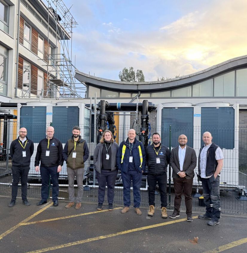ICG engineers examining and discussing a large industrial machine with exposed components.