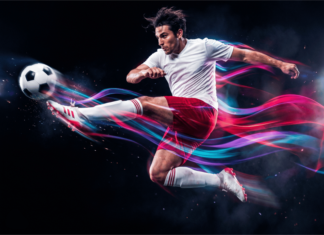 Male soccer player in white and red kicks a ball mid-leap, trailed by colorful light streaks on a dark background