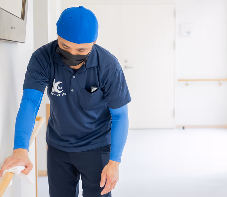 スタッフが施設内の手すり清掃を行う様子