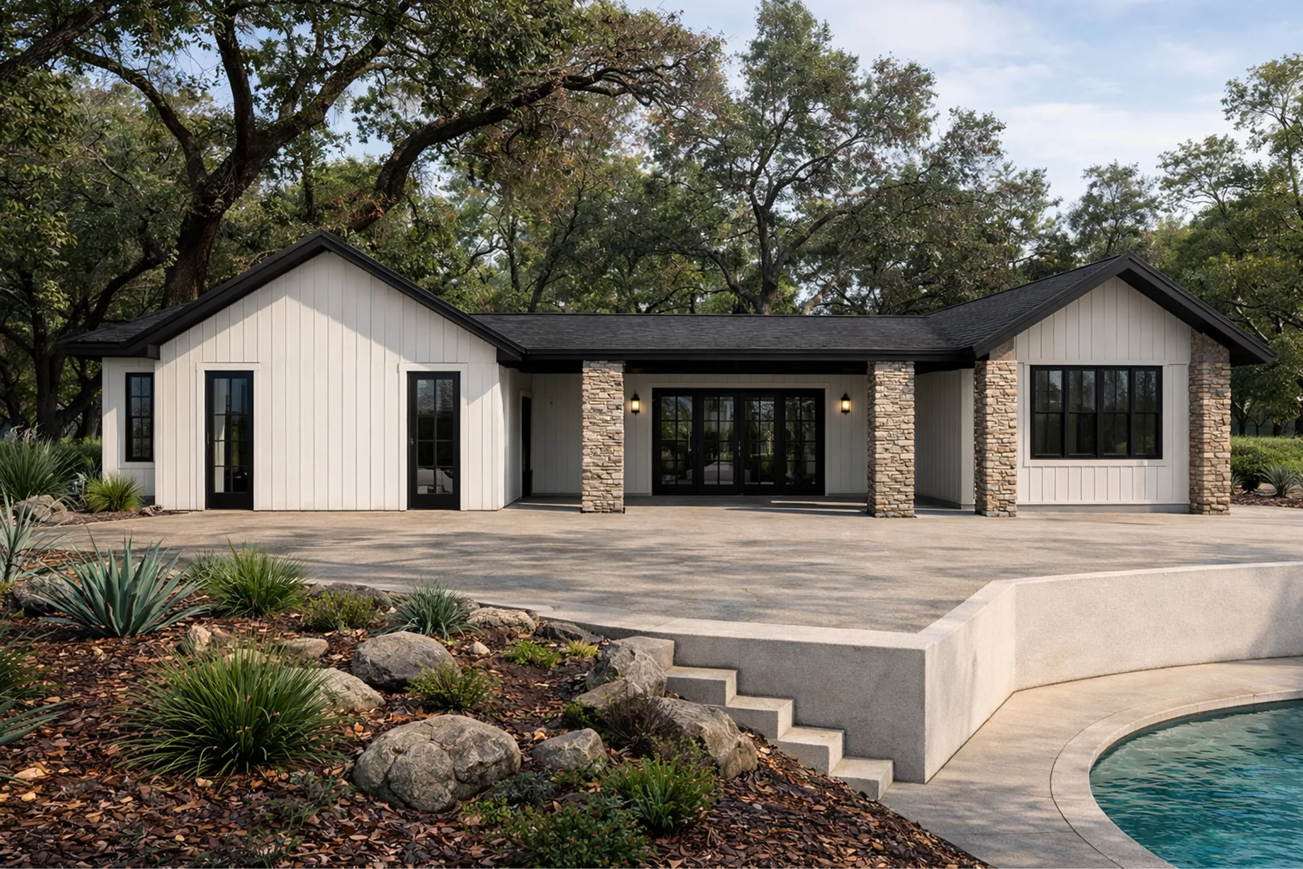 Modern single-story house with white vertical siding, stone pillars, black-framed windows and doors, surrounded by trees and a garden with rocks near a swimming pool.
