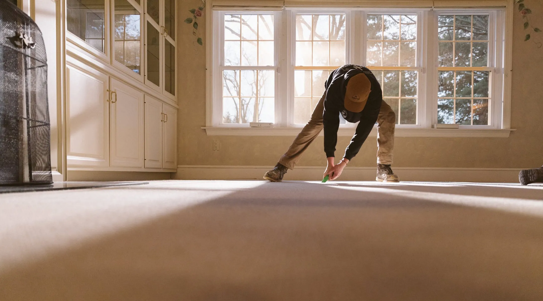 A person bending over on the floor in a room.