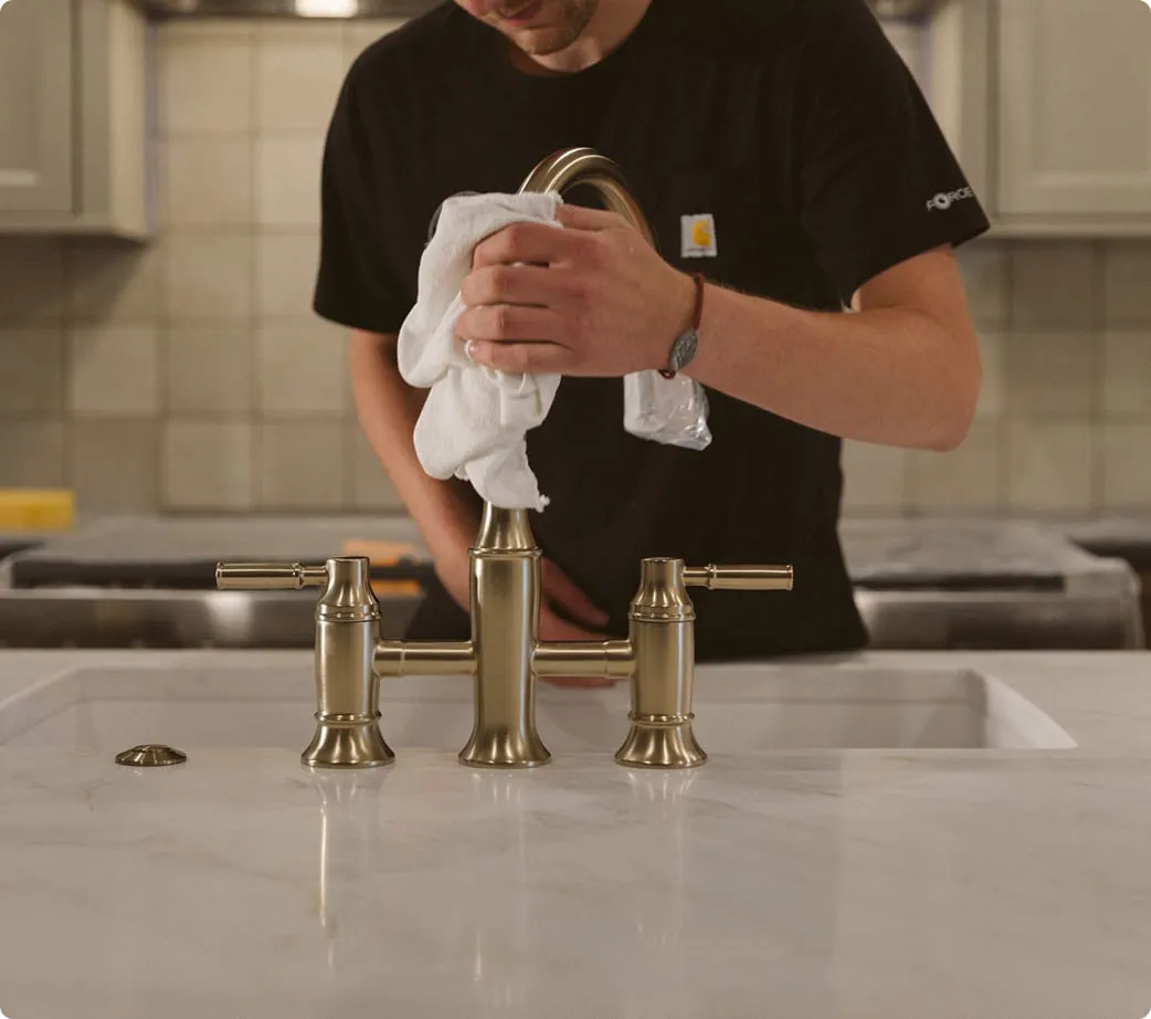 A man wiping his face in a kitchen sink.