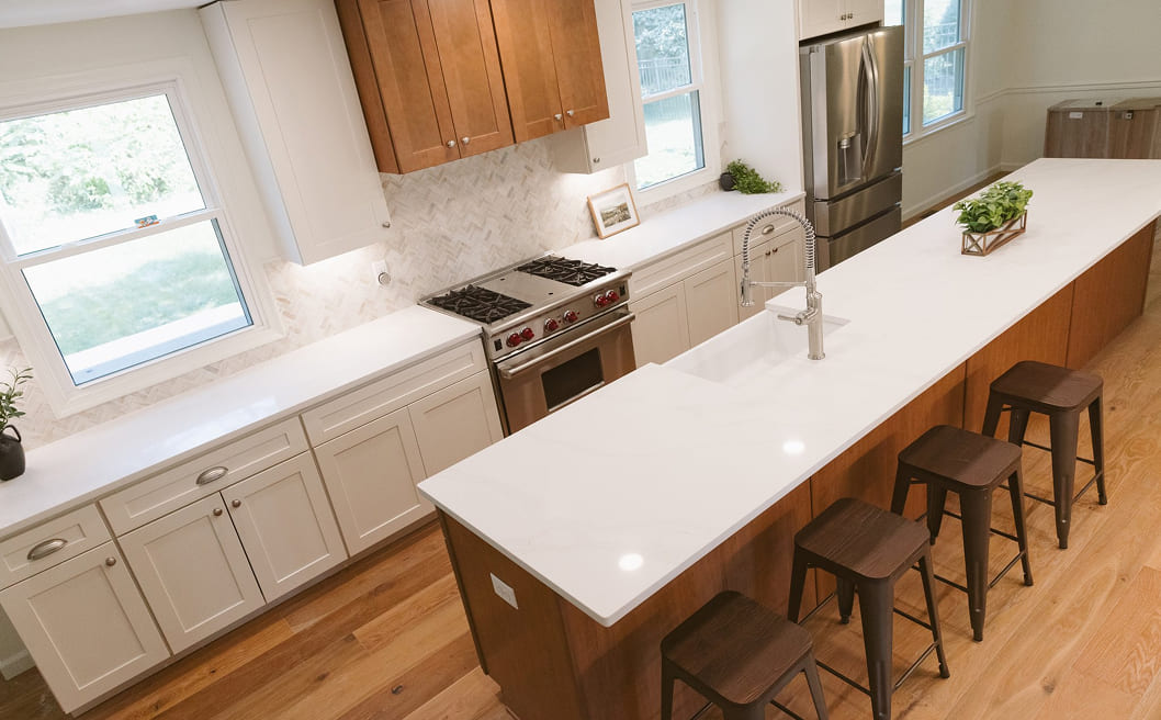 A kitchen with a center island with stools.