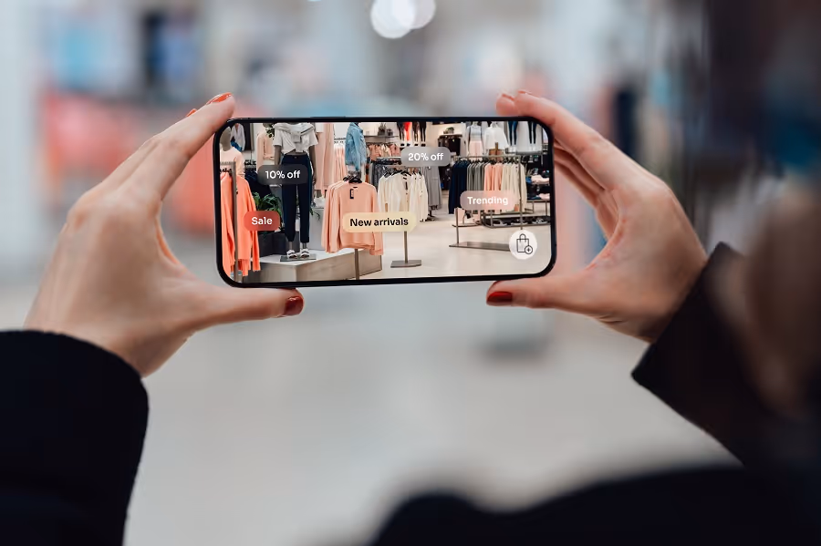 Female hand holding smartphone using augmented reality application to check special sale price in retail fashion store. Shopping with innovative technology makes our life easier. Mockup image for woman using smartphone.