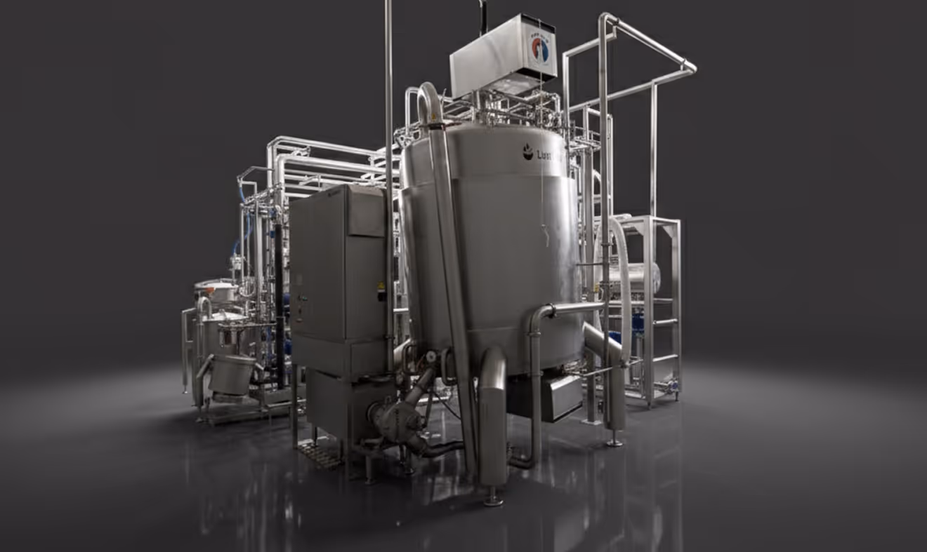Large stainless steel industrial machine with pipes and control box on shiny floor against dark background.