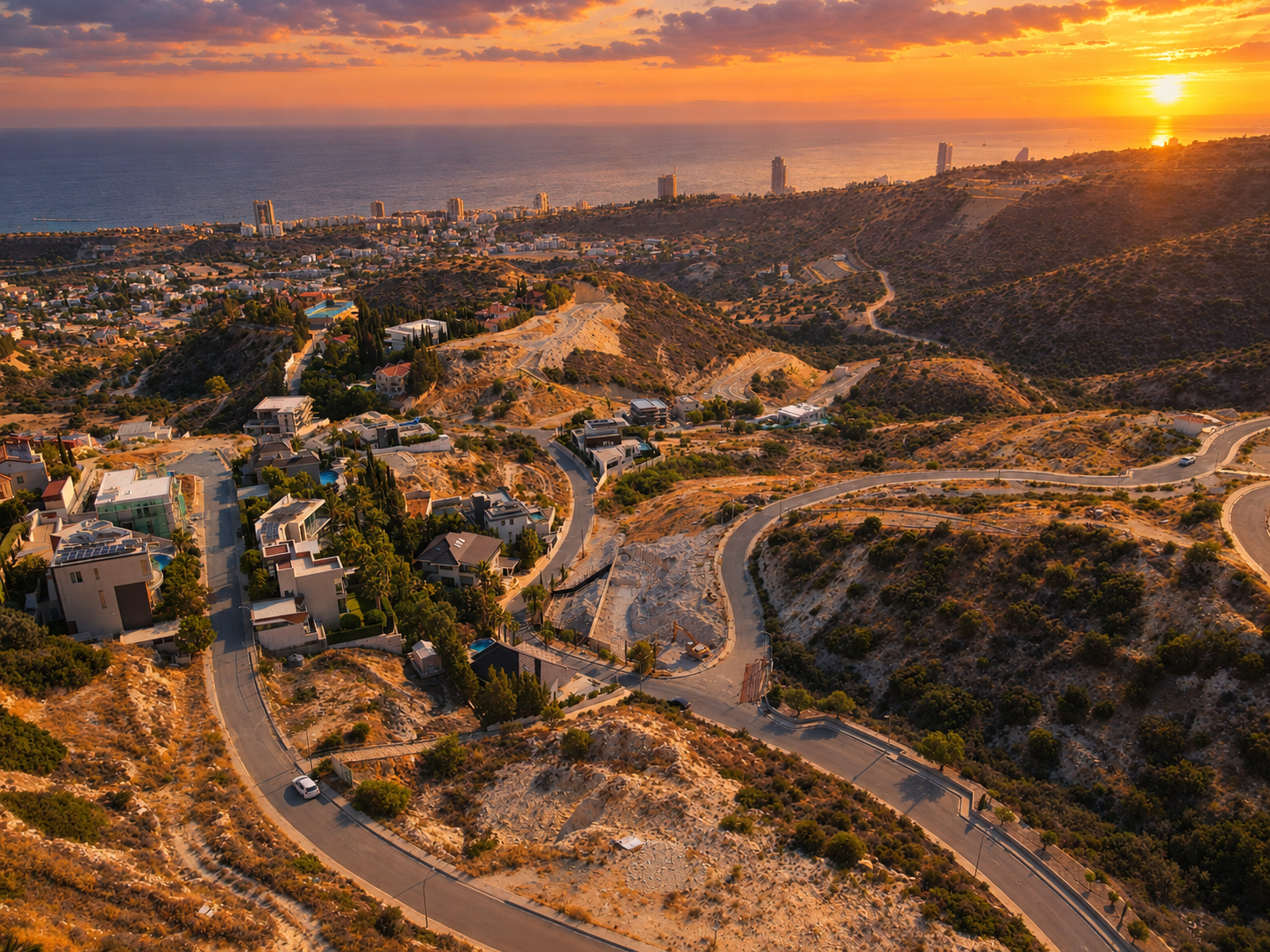 Aerial view of the Ayios Tychonas hillside at sunset, looking over Limassol and the sea