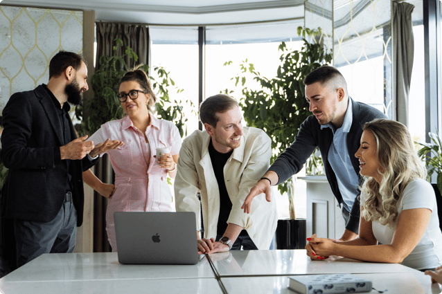 A team of sales leaders analyses data on a laptop and discusses strategies for optimising their sales pipeline.