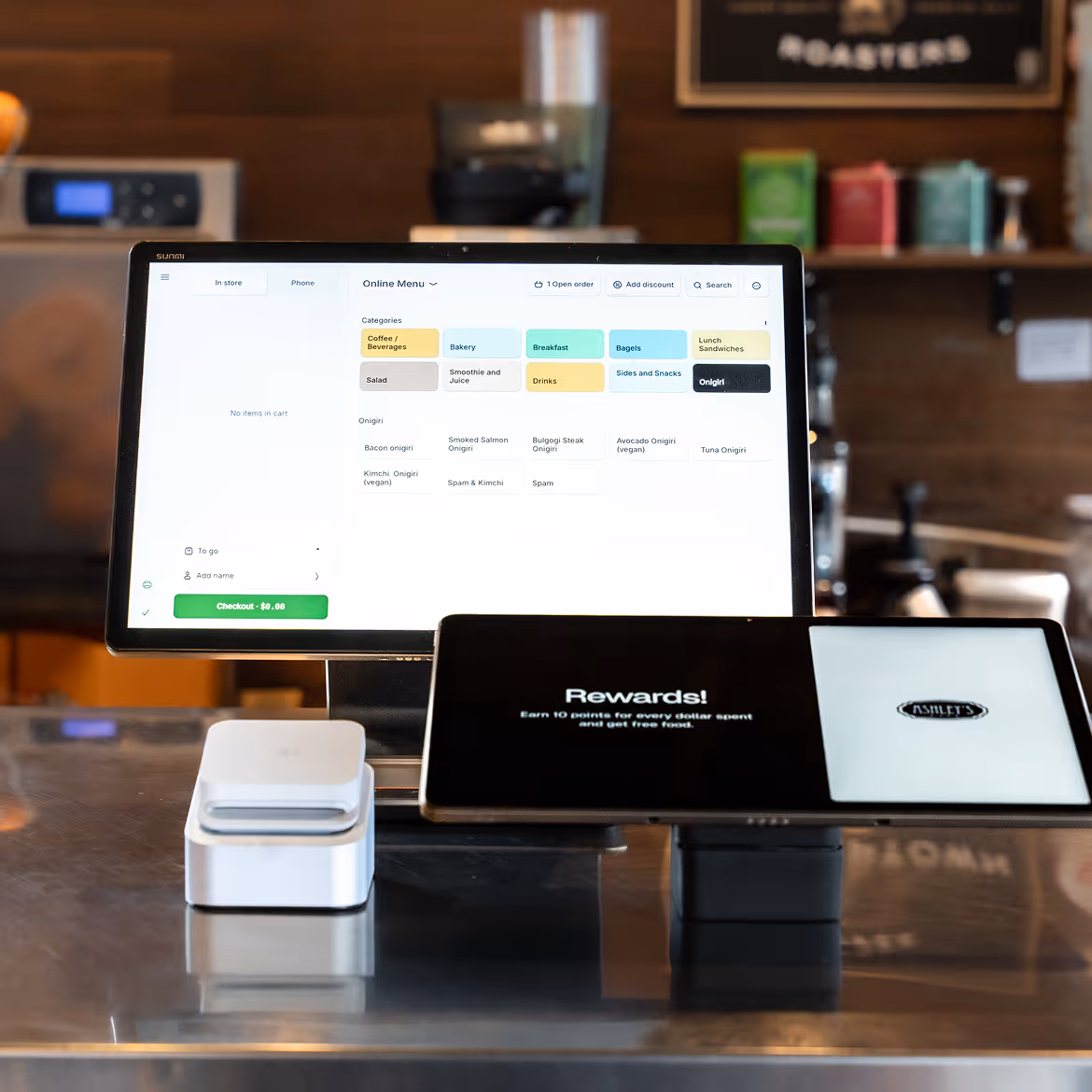 Point of sale system with touchscreen displaying an online menu and a smaller screen showing rewards information on a countertop.